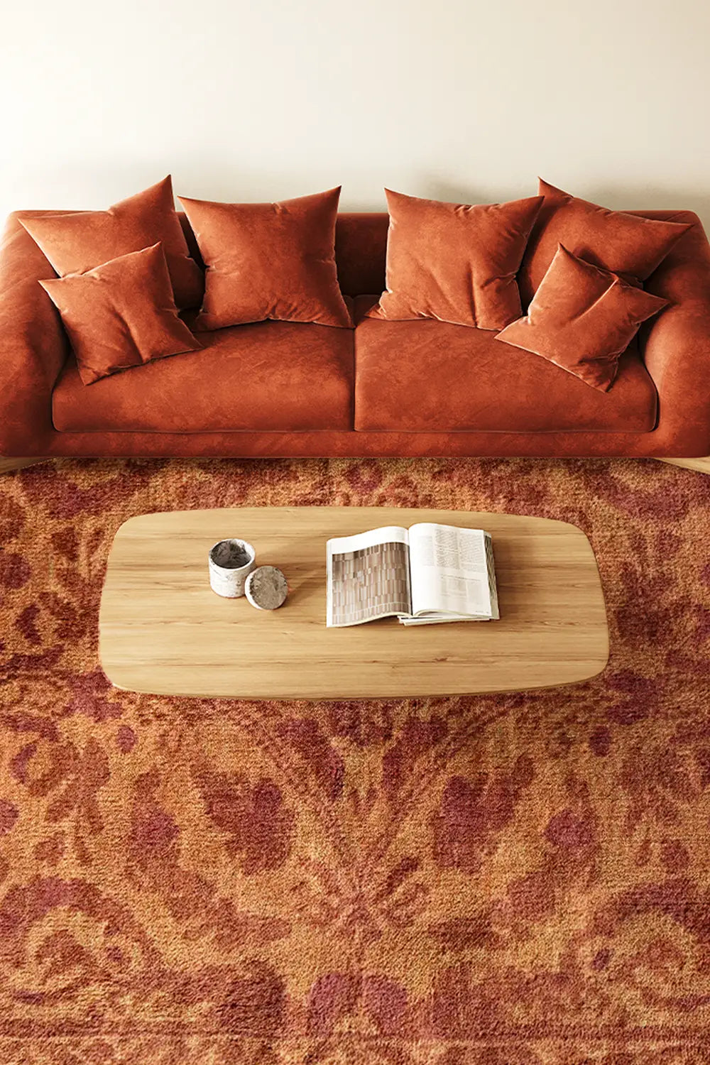 8x10 burnt orange persian rug with traditional floral motifs in a modern living room with rust couch and wood table