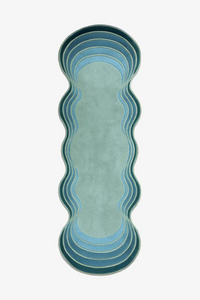 Wavy-patterned runner rug with gradient blue, green and teal colors on a white background