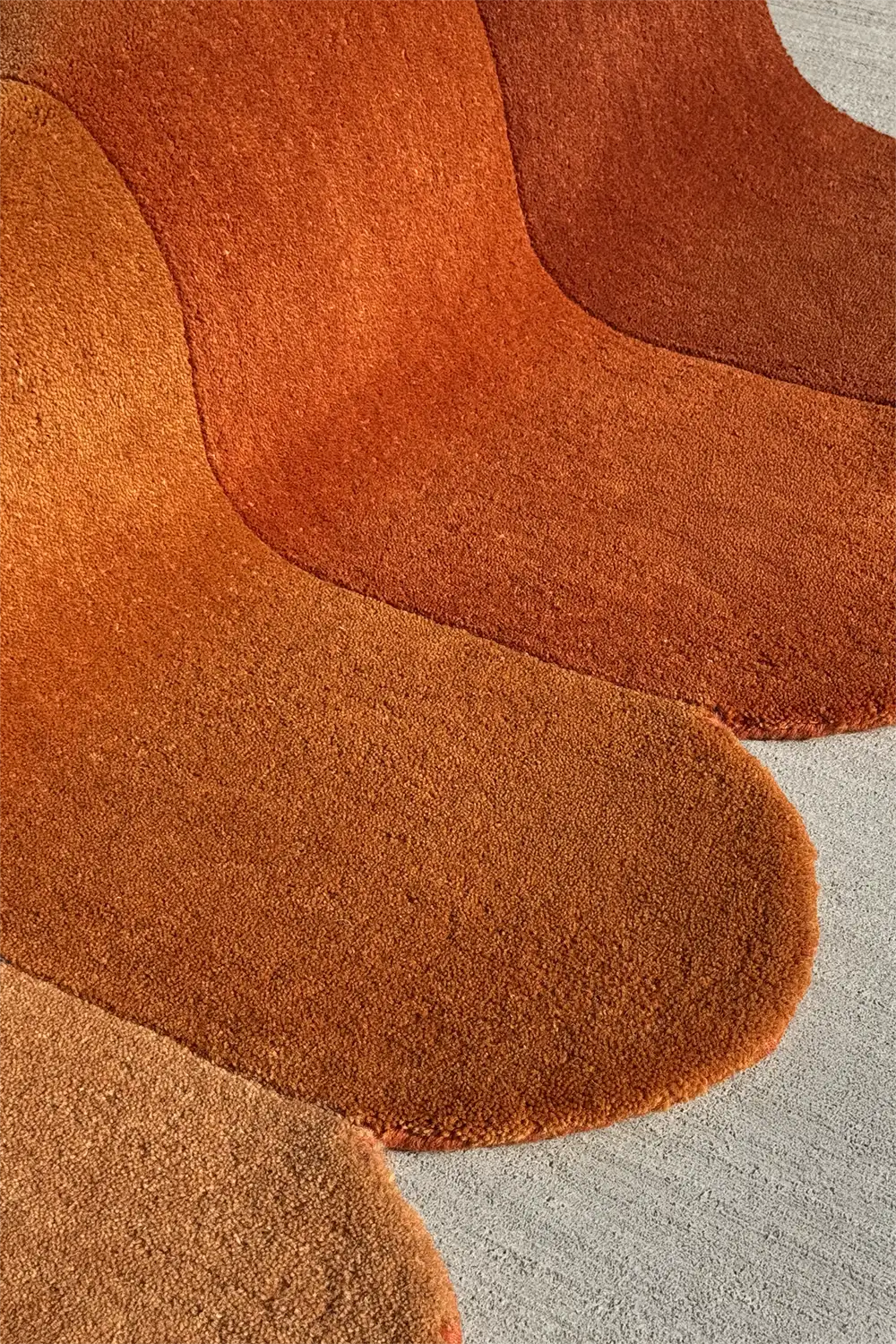 Terracotta and gold rug with irregular rounded edges, a bold neutral statement piece