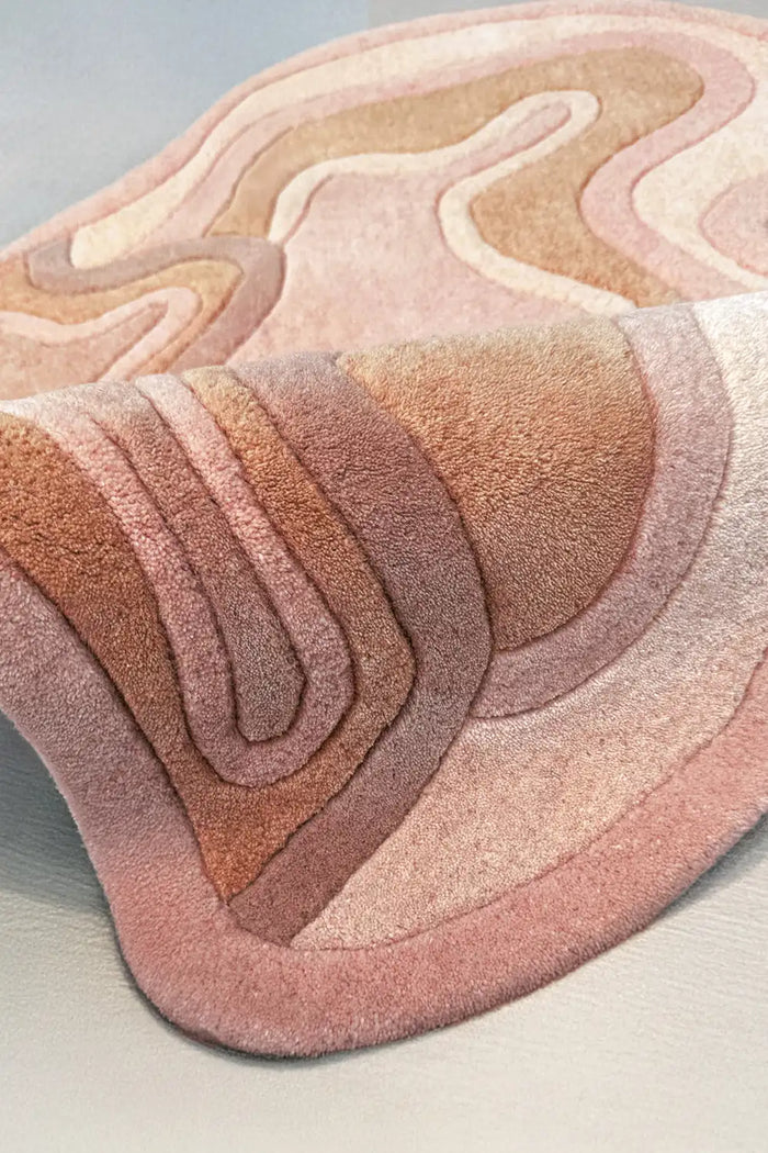 Hand-tufted wool rug in soft orange rust with raised flowing contours, cozy modern accent