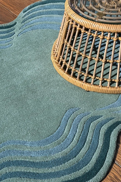 Teal rug with wavy pattern and woven basket on wooden floor