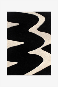 A rectangular area rug with a bold abstract pattern of thick, wavy black and cream stripes, shown flat against a light gray background.