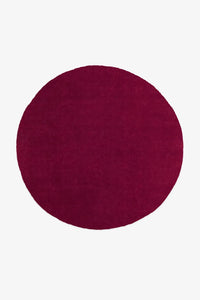 8 foot round burgundy wool rug with hand-tufted plush pile and minimalist solid color design