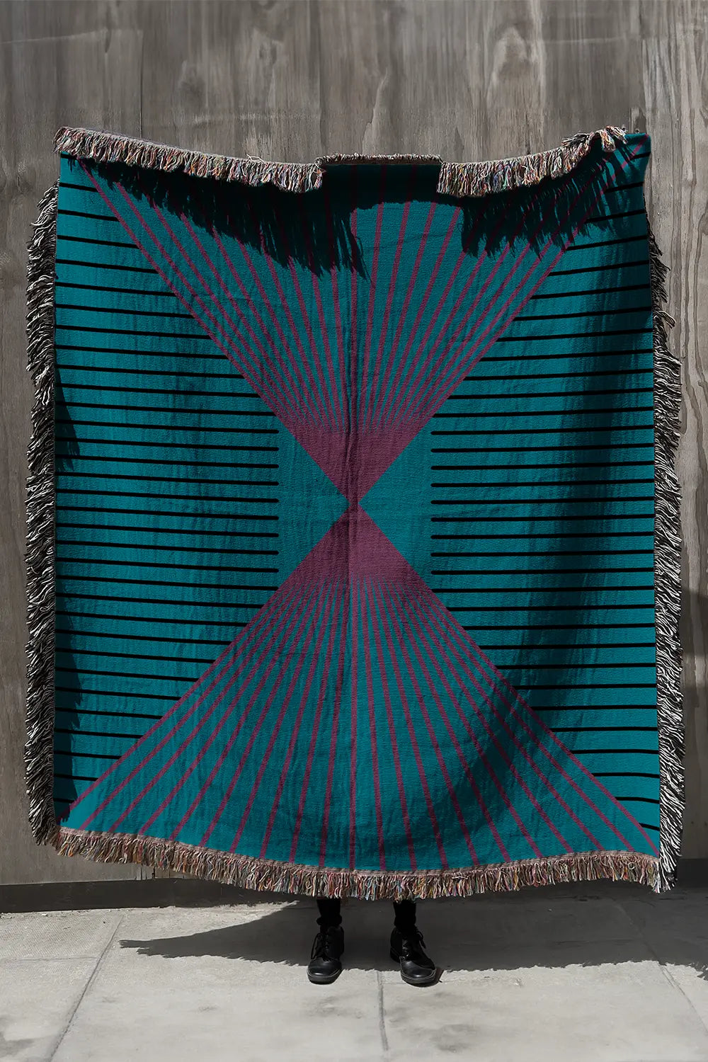90s-style cotton woven throw blanket in teal, pink, and black with a geometric pattern.
