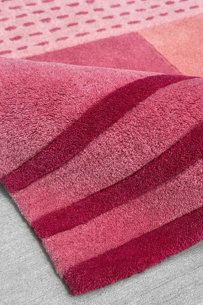8x10 modern geometric pink area rug with tufted pile, sculptural stripes, and varied block tones