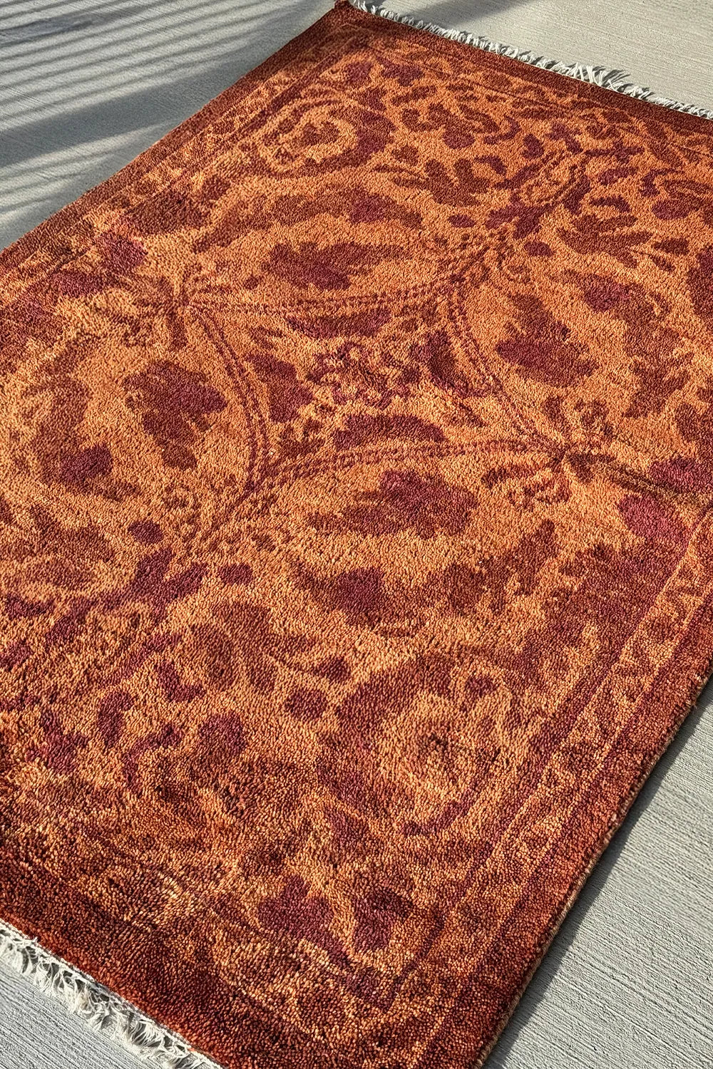 Floral and vine pattern wool rug in terracotta tones, perfect for living rooms.