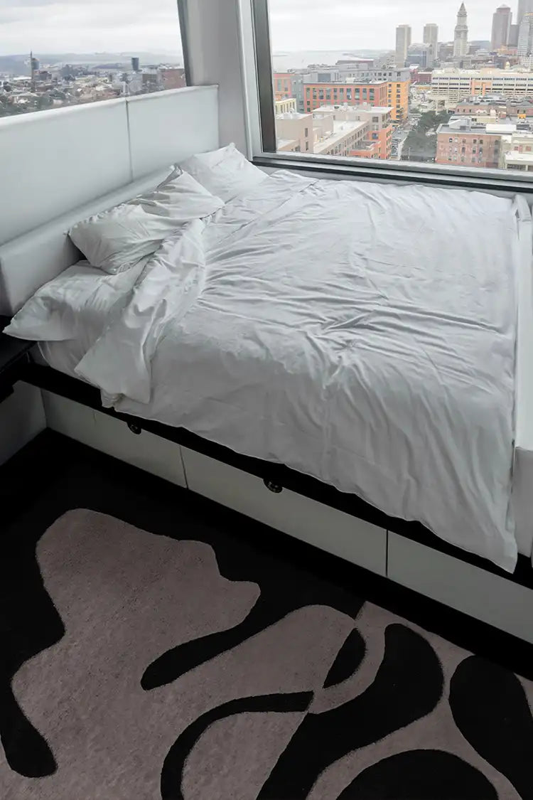 Modern bedroom featuring a black and white abstract wool rug