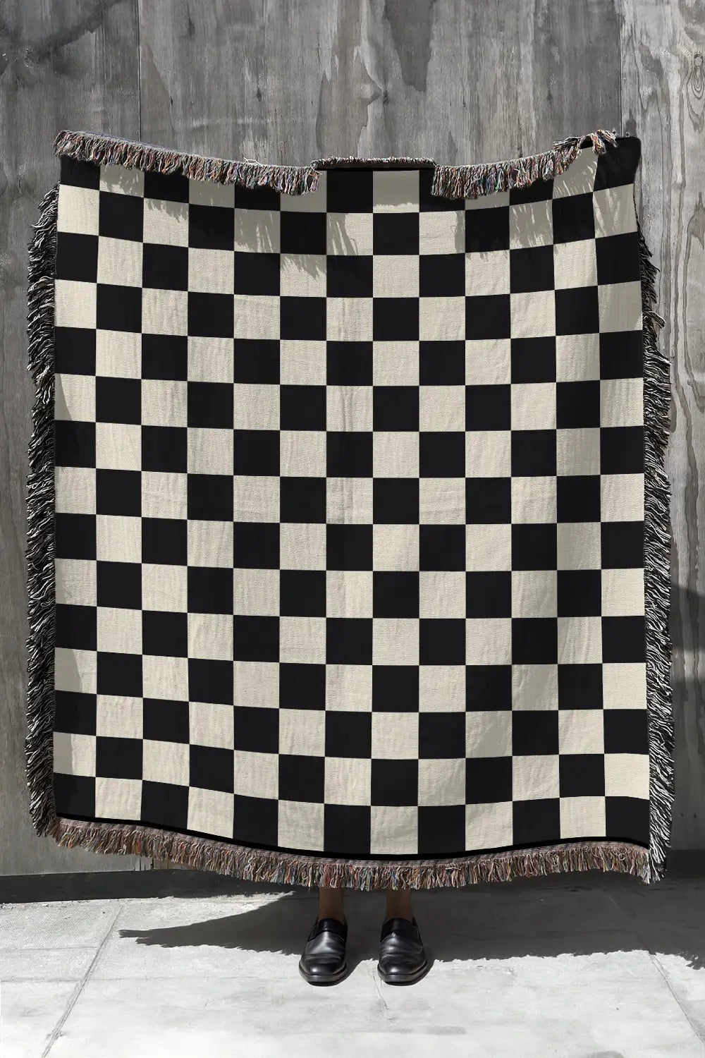 Black and white checkered woven throw blanket with a classic design.
