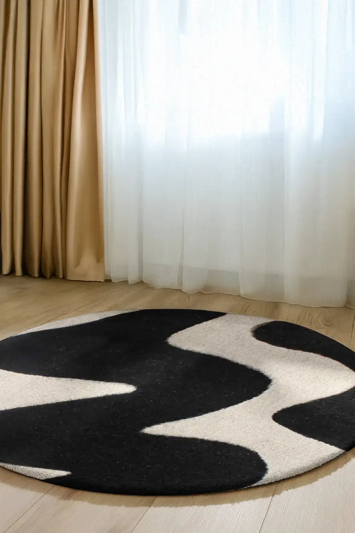 A black and white circular area rug that complements both modern and boho interiors lifestyle