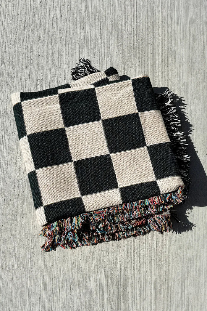 Cotton throw with black and white checker pattern, a timeless woven blanket for modern or Scandinavian interiors
