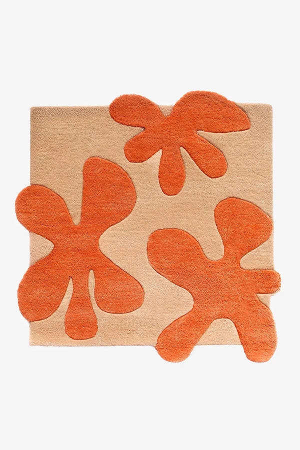 Square hand-tufted wool rug in tan with bold 3D orange floral shapes