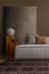 Deep brown handmade wool rug with structured box design in an organic modern living space lifestyle