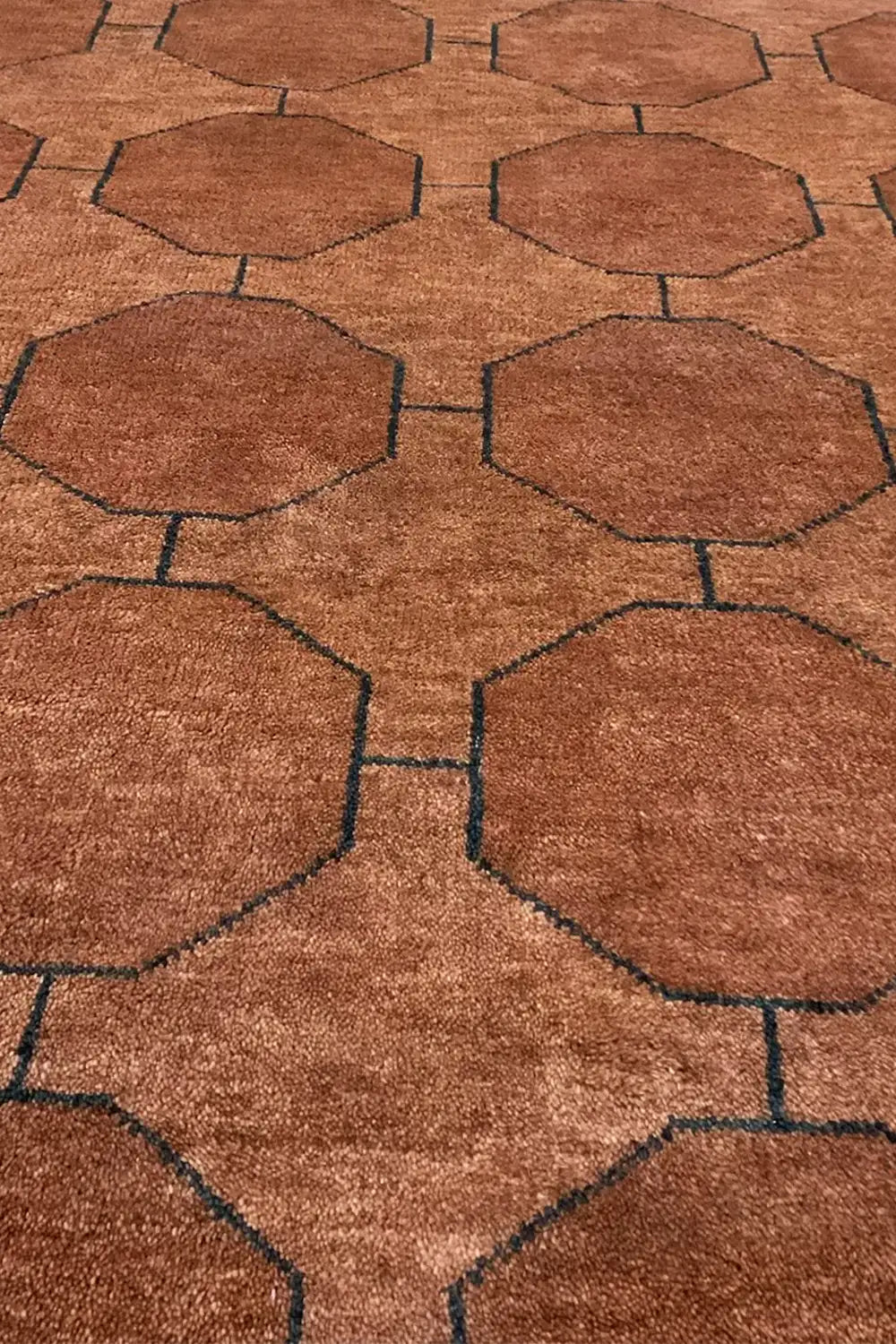 A detailed close-up of the brown geometric rug, emphasizing the intricate woven texture and structured octagonal pattern