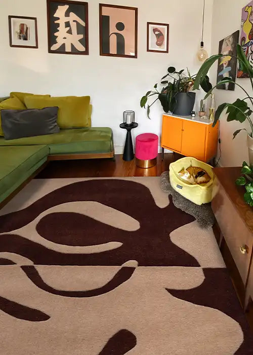 A neutral brown and black area rug with curving, organic lines, seen in a cozy living room setting. 
