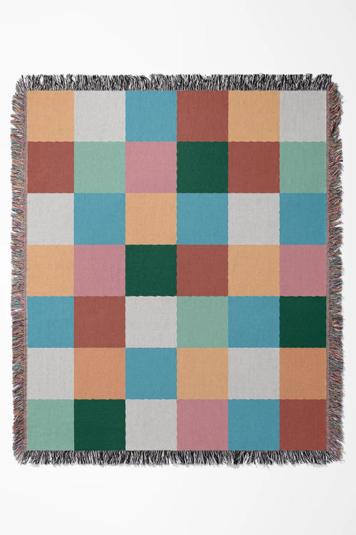 Plaid-inspired cotton woven throw blanket featuring a modern mulittcolor checkered pattern.
