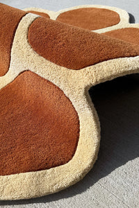 High pile wool texture of a terracotta  and cream novelty rug in an irregular shape for playful modern decor

