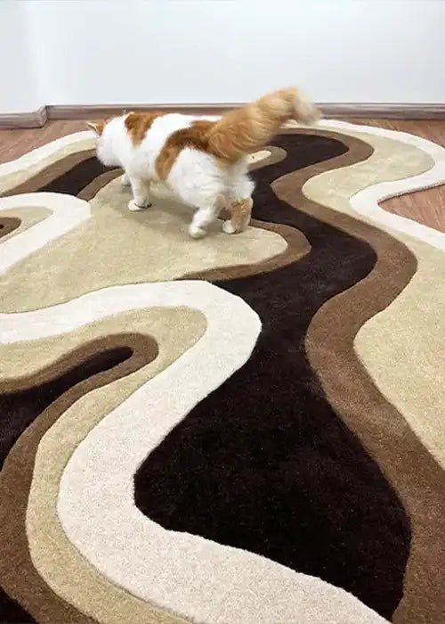 The Rolling Tides rug in earth tones, styled in a minimal living room with a playful cat exploring the organic design