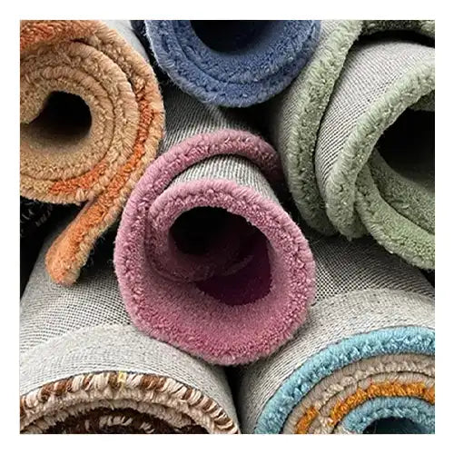 A stack of rolled-up rugs in vibrant colors, showcasing recyclability and the sustainable lifecycle of Jubi rugs