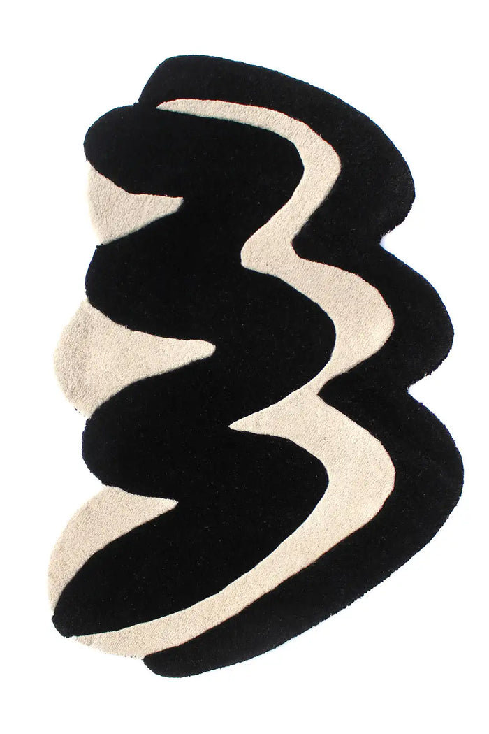 Hand-tufted black and ivory sculptural wool rug with wavy abstract lines and thick plush pile