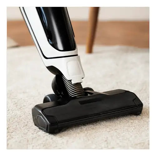 A modern vacuum cleaner on a soft beige rug, ideal for gentle maintenance of handmade rugs.