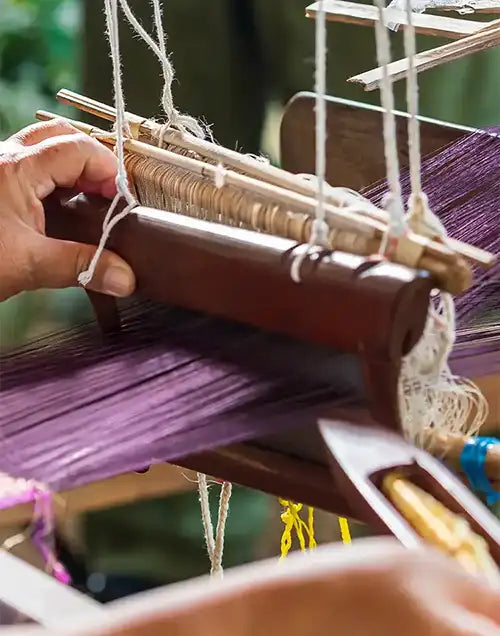 A skilled artisan weaving a vibrant purple rug on a traditional loom, emphasizing handcrafted techniques and precision