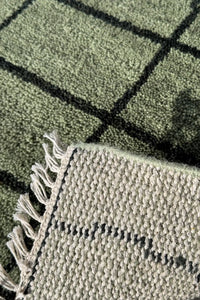 Modern grid wool rug in sage green, featuring natural fringe, available in 5x5 and 6x6 sizes