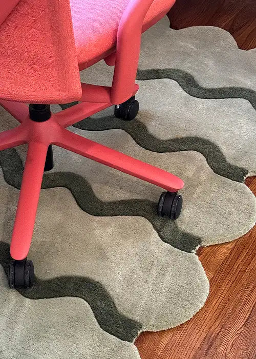 Sculpted Edge Rug in sage green styled in a workspace, positioned beneath a coral office chair, highlighting its bold yet functional design.
