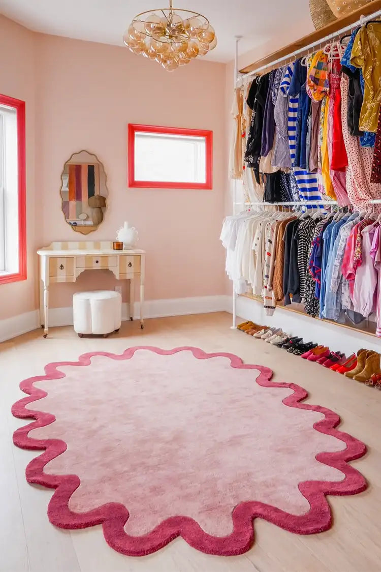 A playful pink and red scalloped-edge rug anchors this vibrant dressing room, adding a soft and artistic touch to the space.