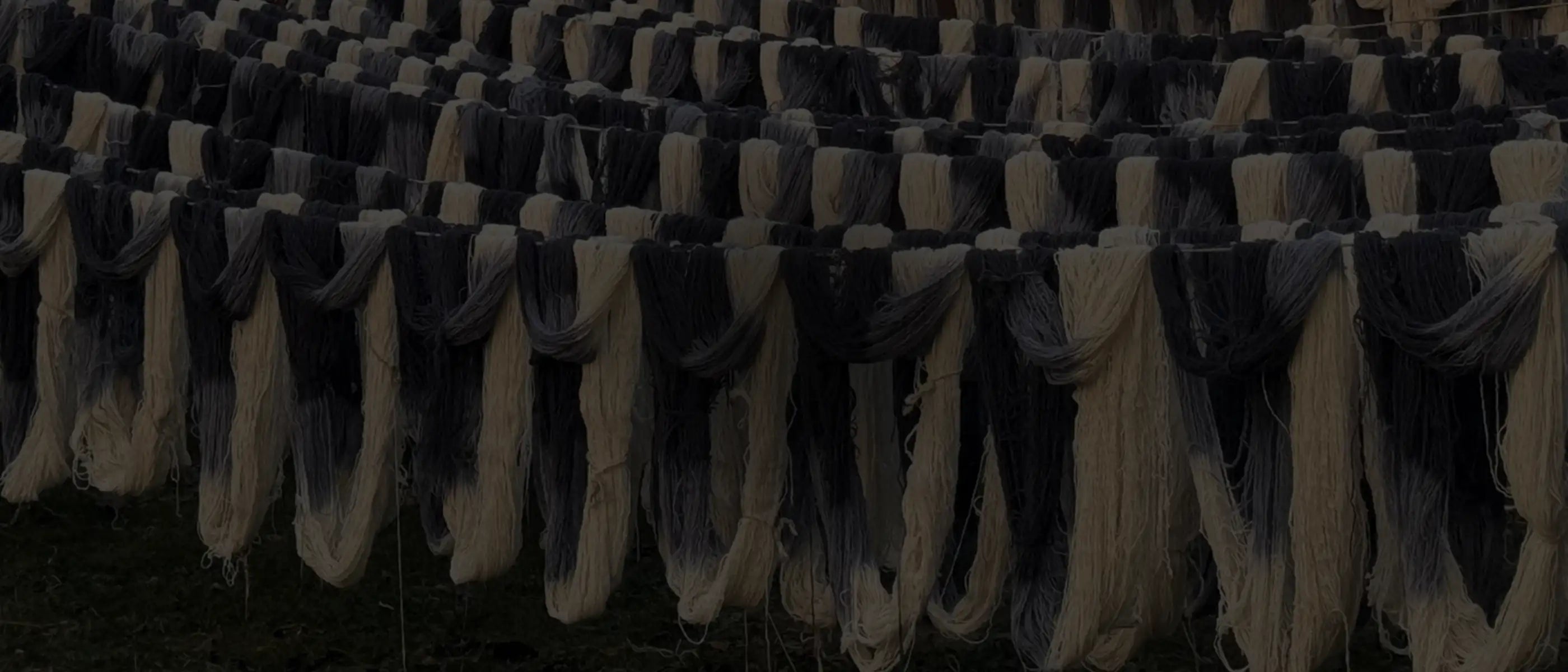 Rows of natural wool yarn hanging to dry, showcasing sustainable and eco-friendly rug materials