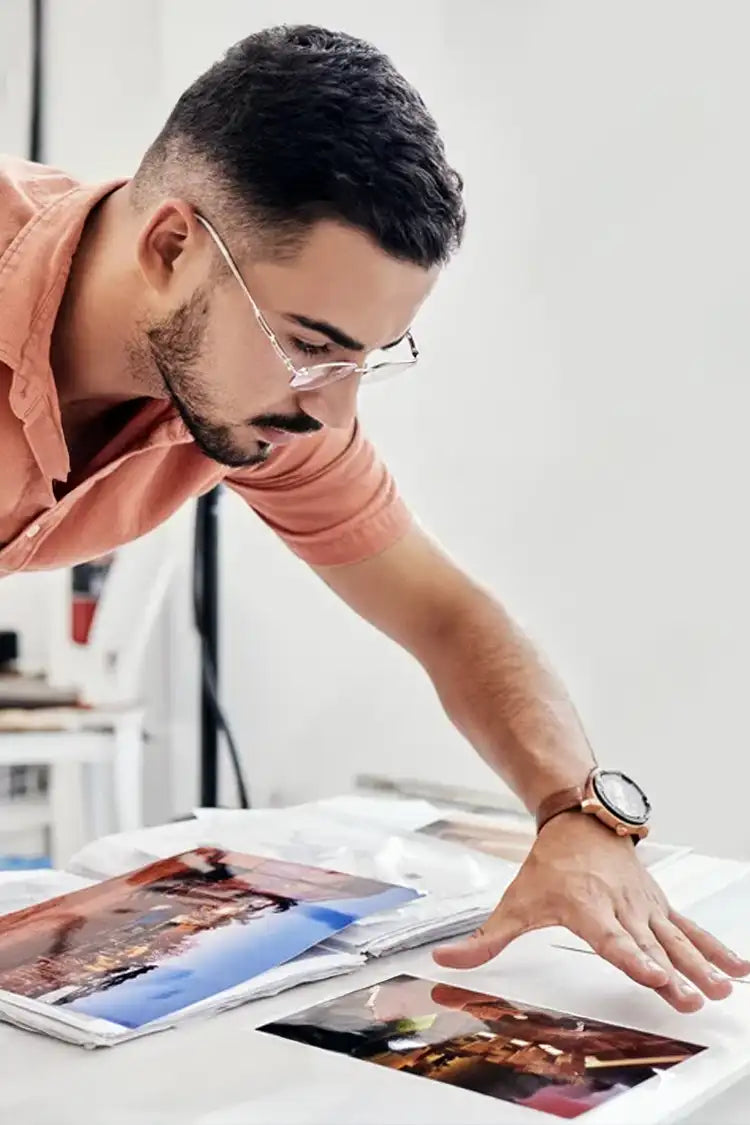 Artist inspecting fine art prints in a studio, ensuring museum-quality precision and durability.