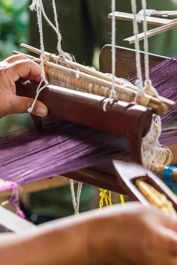 Artisan hand-weaving a custom rug on a traditional loom, showcasing expert craftsmanship