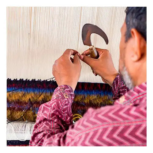 Skilled artisan weaving a custom rug by hand with premium materials