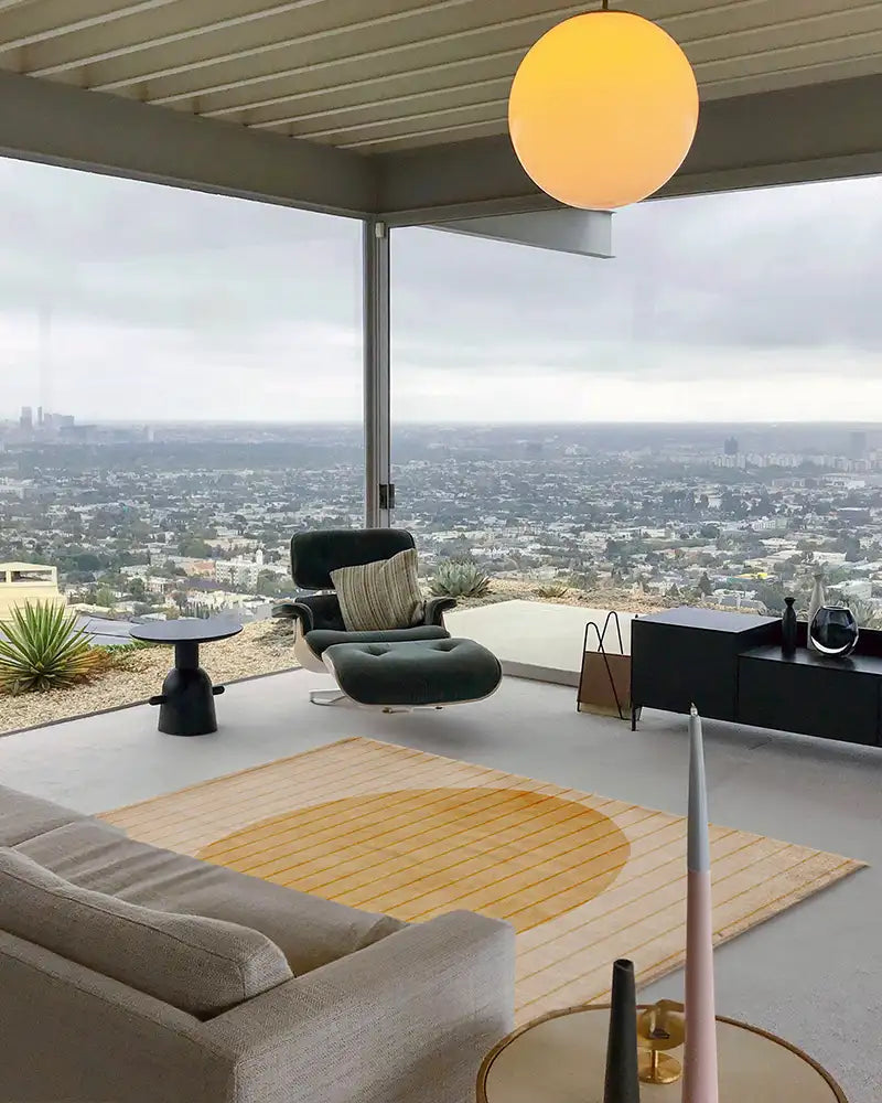 A modern living room featuring a yellow tufted rug with a circular pattern, styled with contemporary decor.