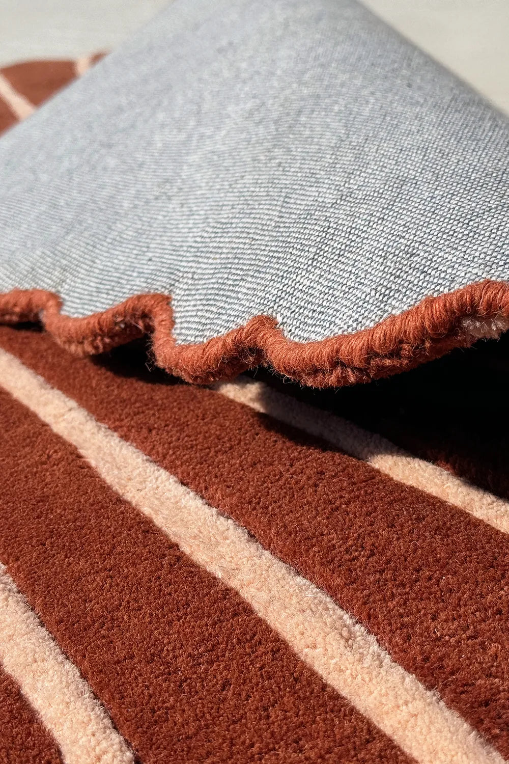 Tufted wool rug with natural backing – organic modern rug in burnt orange with scalloped leaf outline