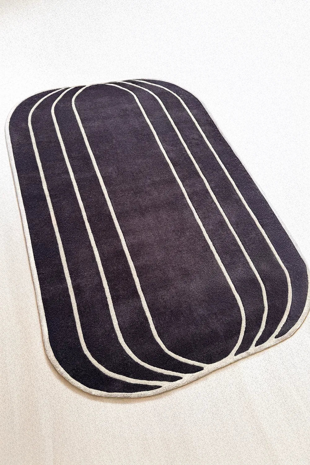 Contemporary abstract black and white rug with irregular rounded edges – handmade wool rug for modern spaces

