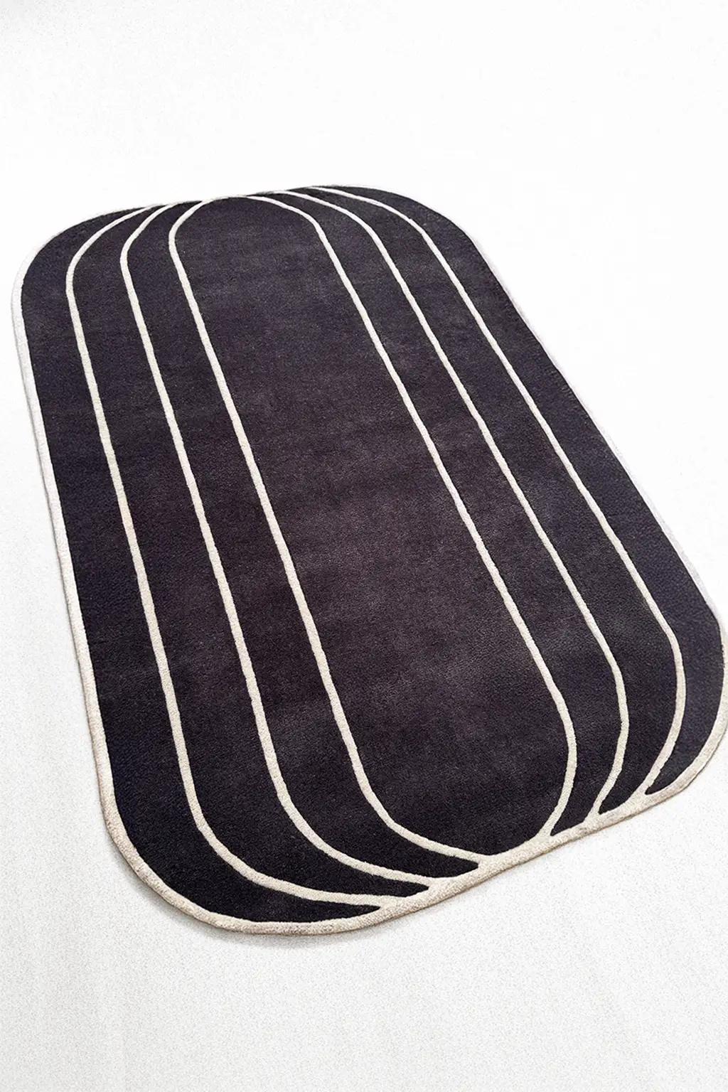 Contemporary abstract black and white rug with irregular rounded edges, a handmade wool rug for modern spaces

