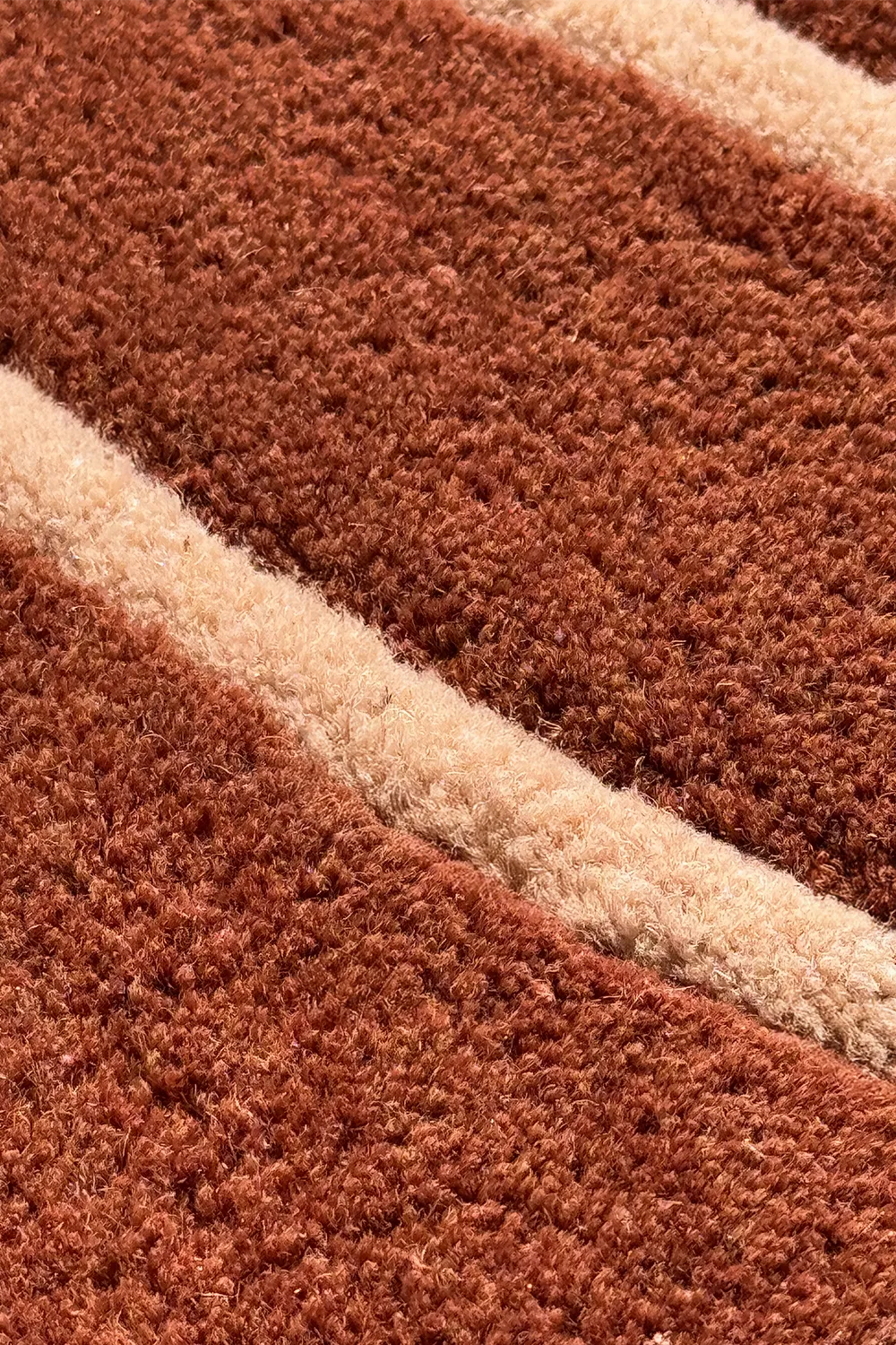 Thick curved edge of rust colored leaf rug – luxury coastal area rug with botanical silhouette
