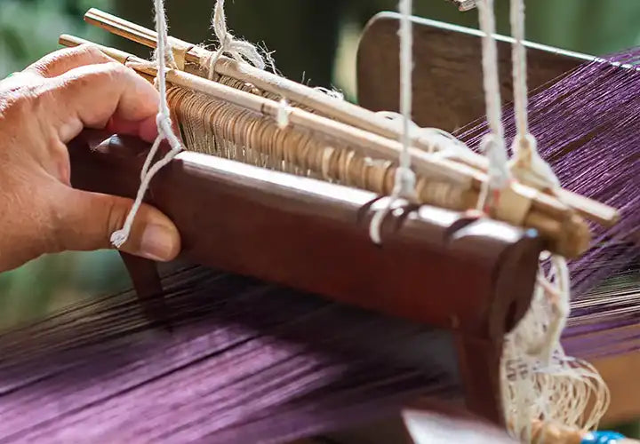 Skilled artisan hand-weaving a custom rug using time-honored techniques