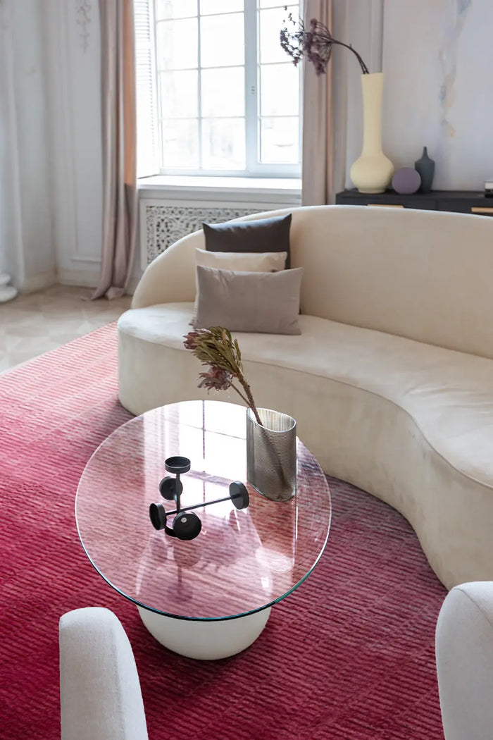 Pink Ombre Loomed Rug in an elegant living room with a curved cream sofa, modern glass coffee table, and soft natural light lifestyle
