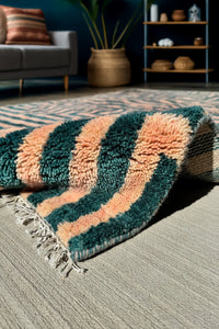 Bold green and peach 5x8 wool shag rug with graphic striped pattern, in a modern living room lifestyle