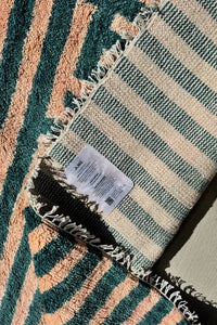 Handmade green and peach shag wool rug showing soft fringe and thick handwoven texture