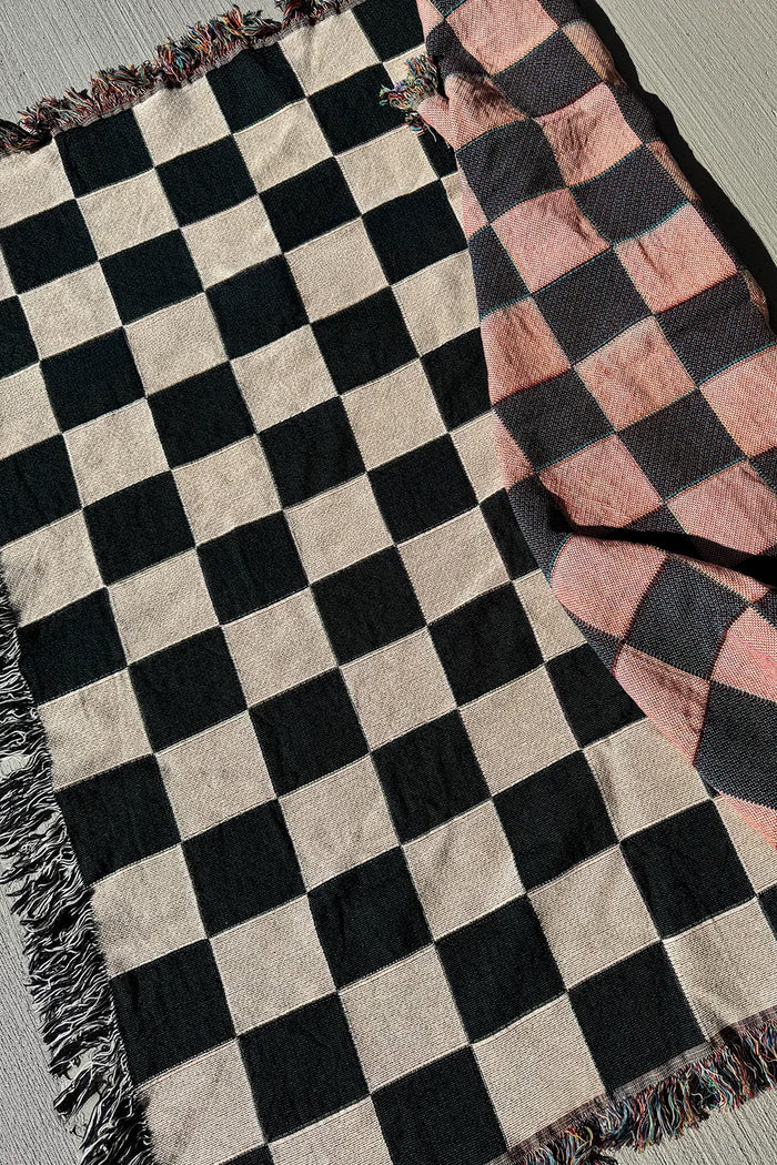 Modern woven throw blanket in black, white, and soft peach checks, perfect for funky cotton throws or multicolor abstract blankets