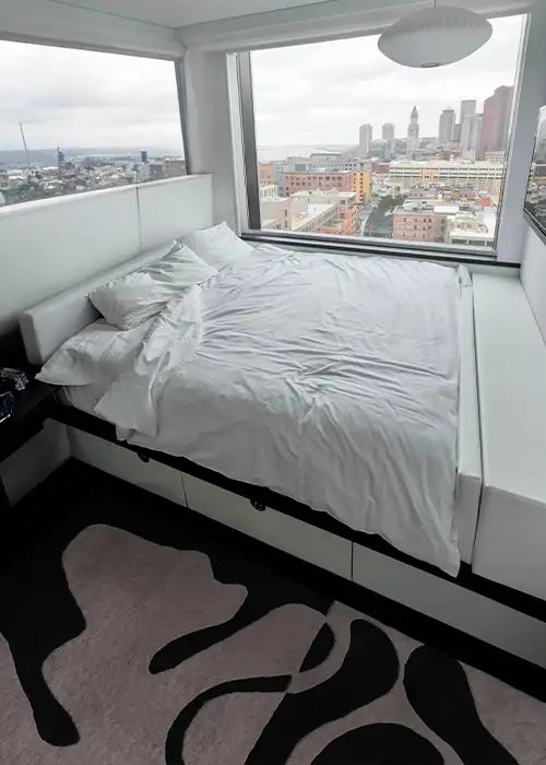 3x5 abstract black and white rug styled in a minimalist bedroom space