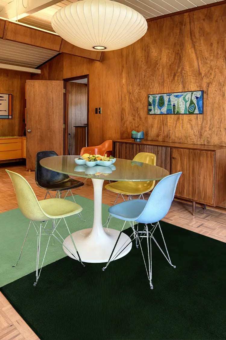 Modern wool rug in olive green and dark green, styled under a dining table