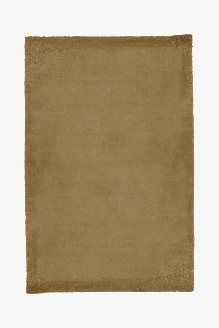 Tan wool rug in camel tone, hand-tufted and plush, great for mid century or boho living room designs