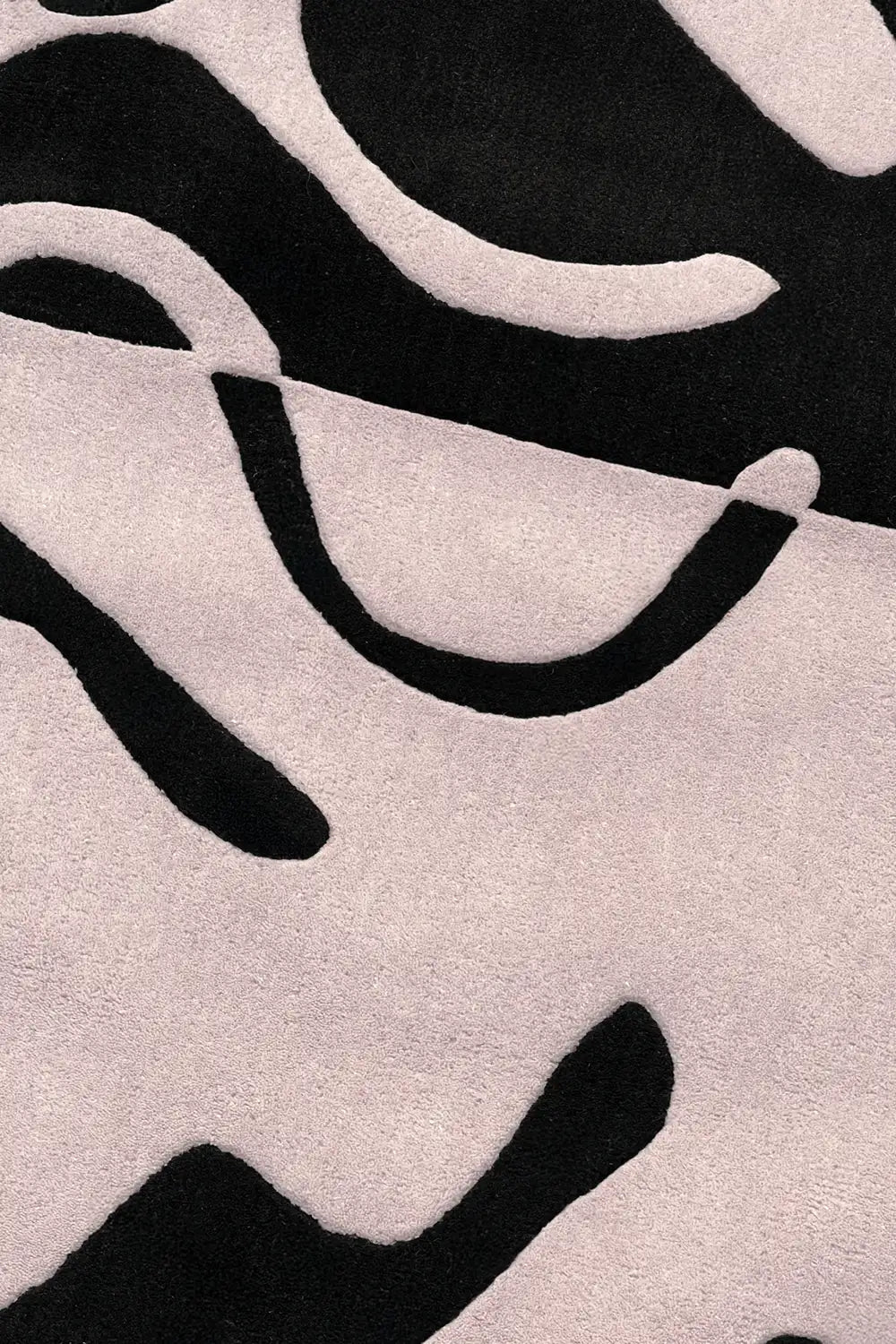Close-up of black and white abstract curves on tufted wool rug