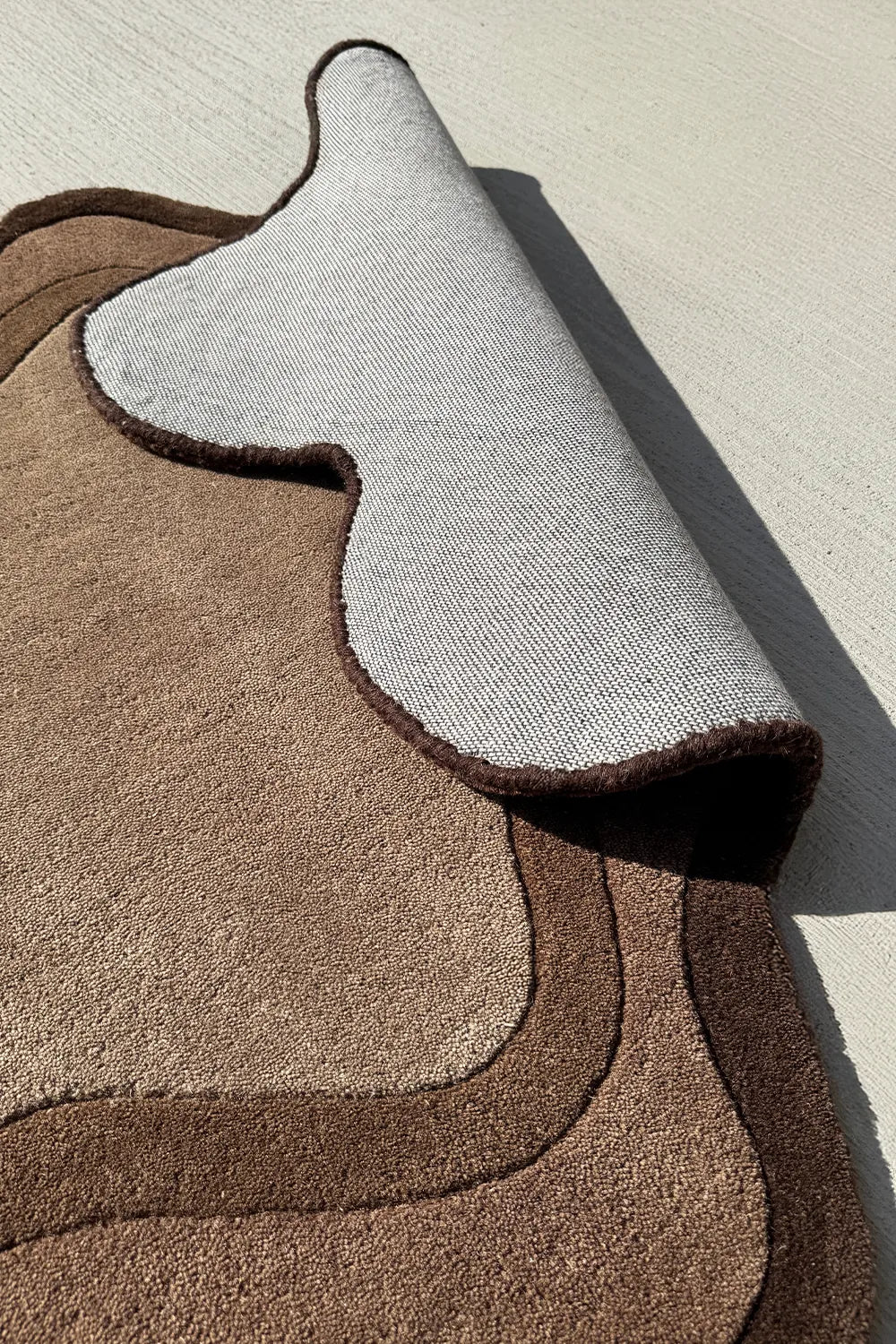 Neutral brown area rug with sculptural silhouette – tufted organic shaped rug with soft backing for cozy contemporary interiors

