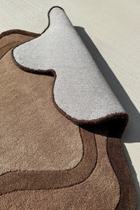 Neutral brown area rug with sculptural silhouette – tufted organic shaped rug with soft backing for cozy contemporary interiors

