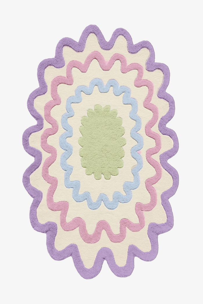 Colorful scalloped oval wool rug in pastel purple, green, and blue, modern boho area rug for playful living rooms and kids' rooms