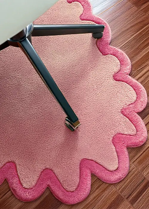 A hand-tufted pink scalloped rug with soft, rounded edges